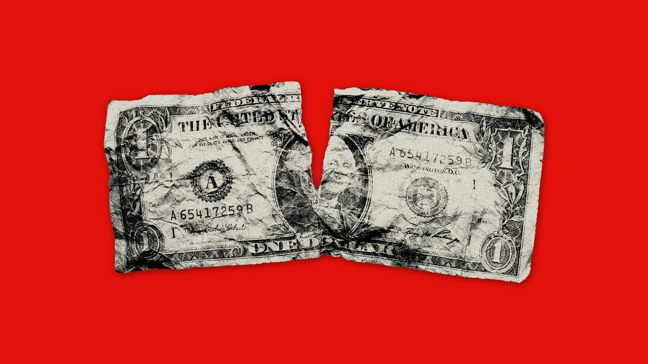 crumpled dollar bill with a rip in the middle on a red background