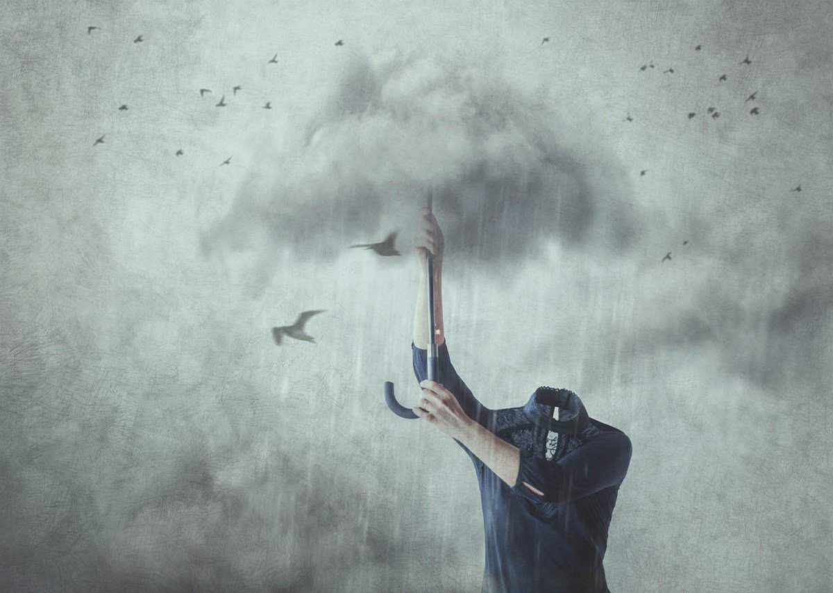 Concept of losing your mind; headless man holding up umbrella made of clouds