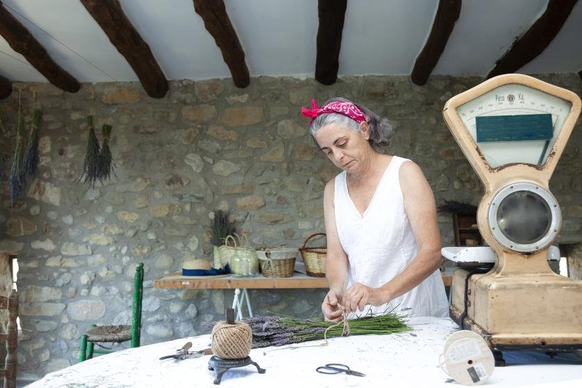 Woman making lavender bouquets in old workshop