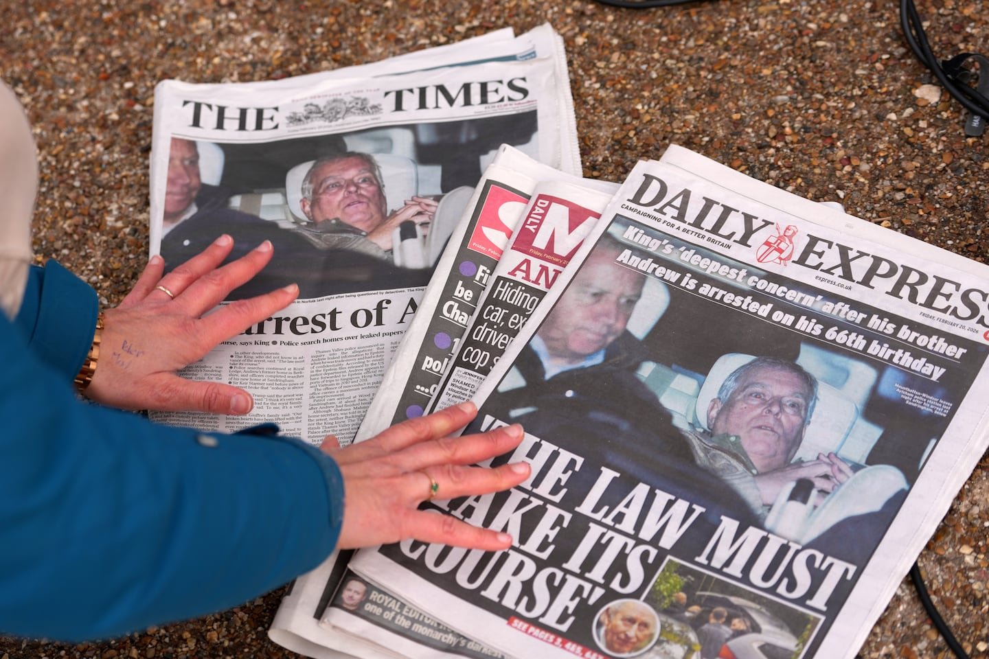 A journalist looked at the day's front pages in London, Feb. 20, after Andrew Mountbatten-Windsor was arrested and held for hours by British police on suspicion of misconduct in public office related to his links to Jeffrey Epstein.