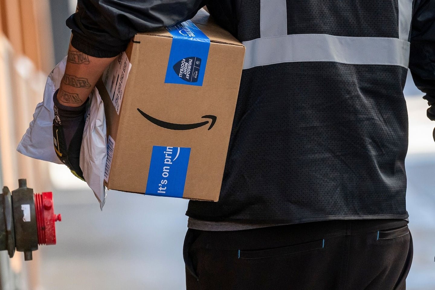 A worker delivers Amazon packages in San Francisco, Calif., on Oct. 24, 2024.