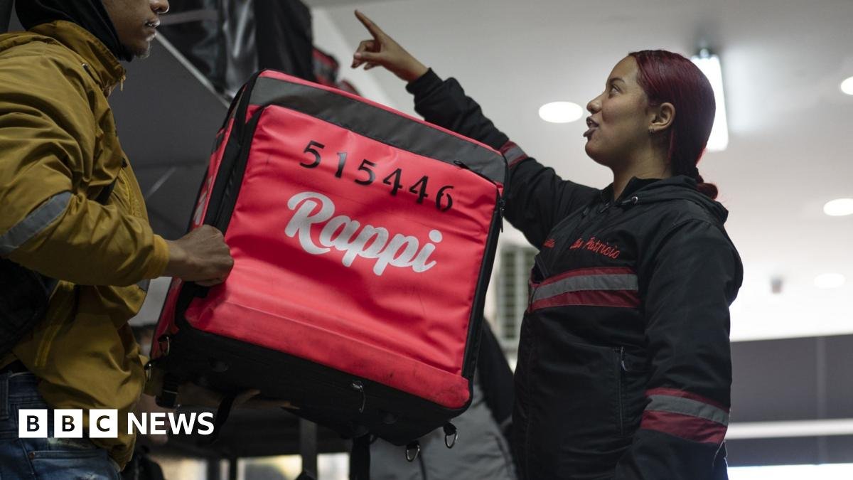 Two Rappi delivery drivers - the nearest has a large, red backpack with the Rappi logo.