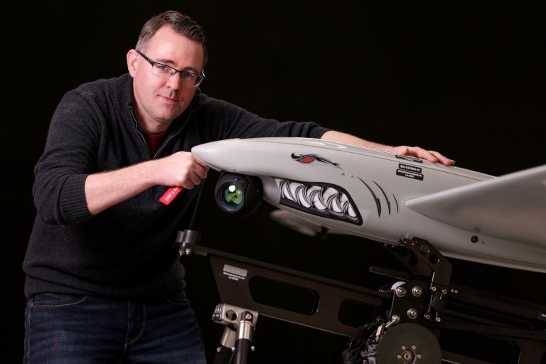 Ukrspecsystems Managing Director Rory Chamberlain poses for a photograph with one of the company's Shark reconnaissance drones at their UK factory near Cambridge, eastern England