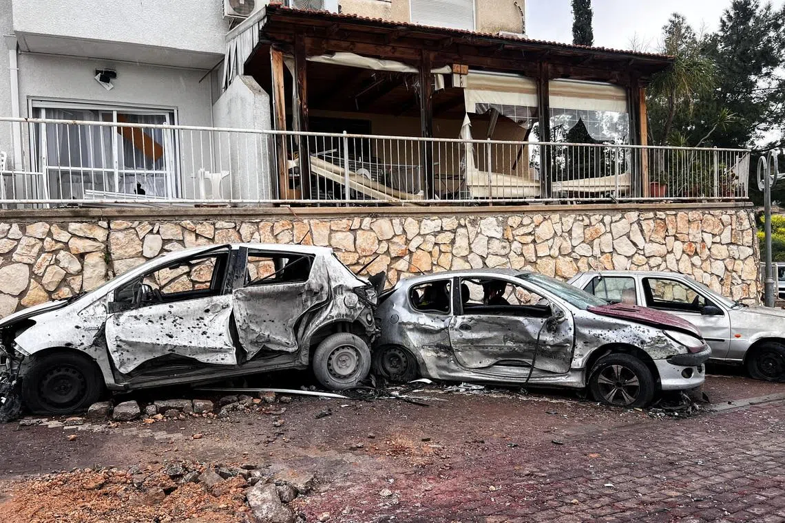 Damaged vehicles and buildings, after a projectile was launched towards Israel from the Iran-backed Hezbollah in Lebanon, following an escalation between Hezbollah and Israel amid the U.S.-Israeli conflict with Iran, in northern Israel, March 14, 2026. REUTERS/Avi Ohayon
