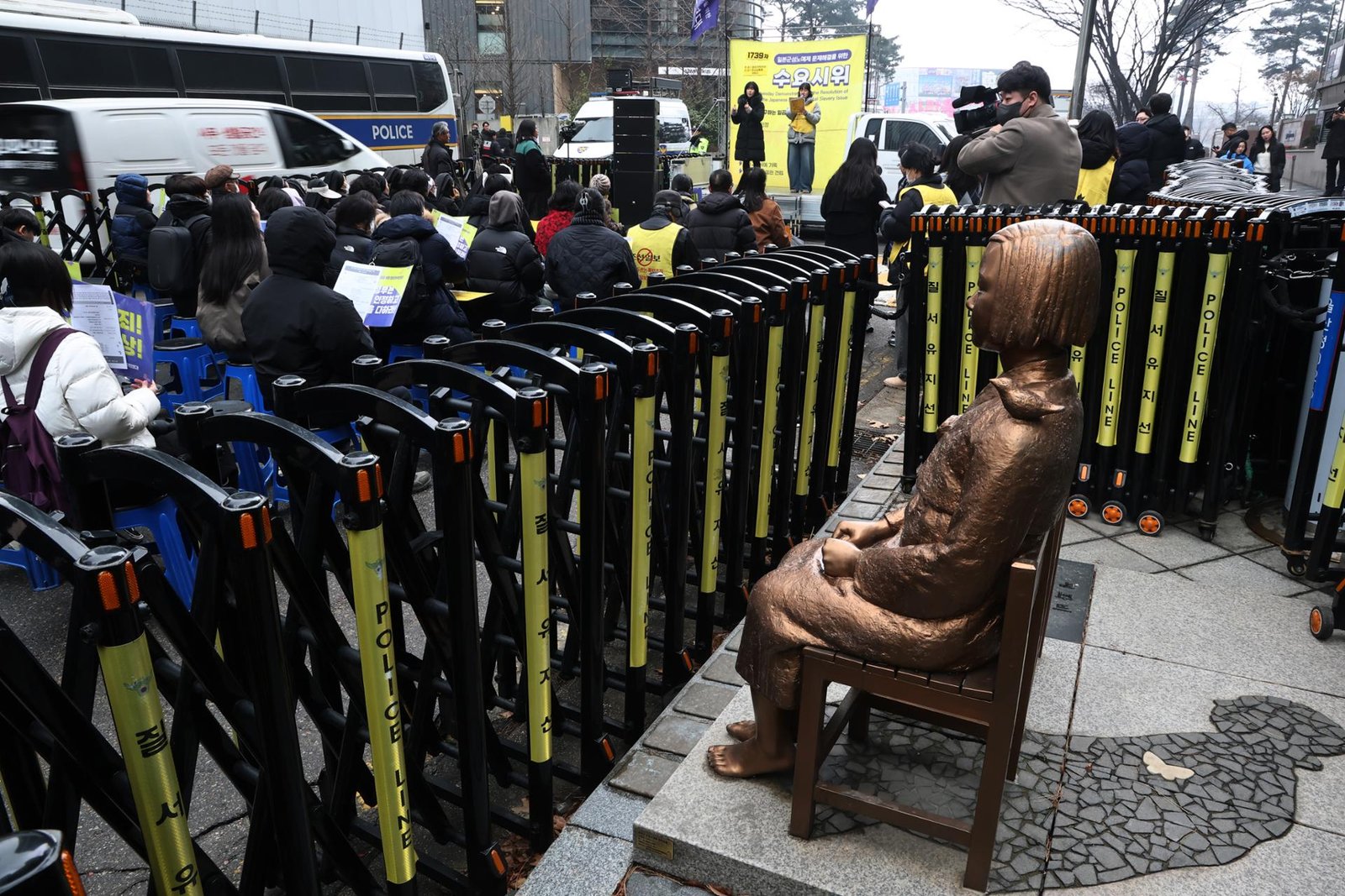 Protestors gather in front of a girl statue honoring the victims of sexual slavery by Japan