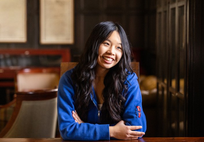 Abigail Chow, UTulsa alumna and fintech founder, smiling in a wood-paneled room.