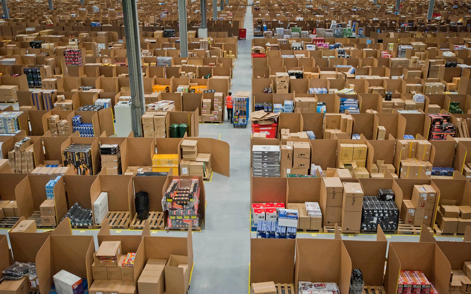 Rows upon rows of stacked boxes in an Amazon warehouse pictured from an arial viewpoint