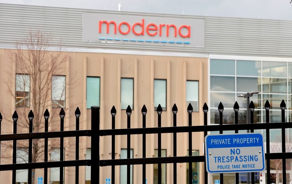 Image of a building with the Moderna logo behind a security fence.