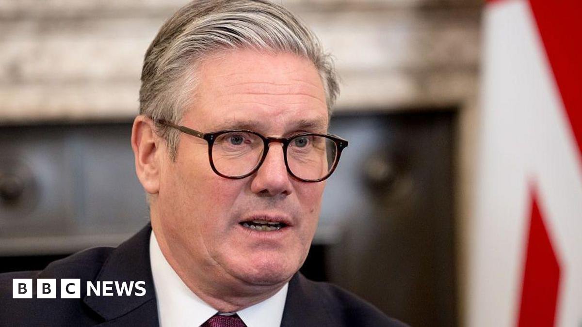 A close up of Prime Minister Sir Keir Starmer in Downing St, with a blurred background and the UK flag behind him.