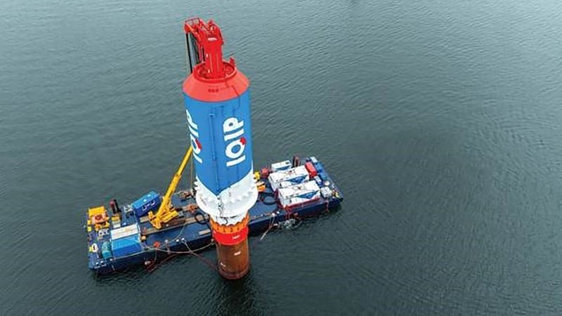 A complete monopile bearing the IQIP logo is anchored in the seabed.