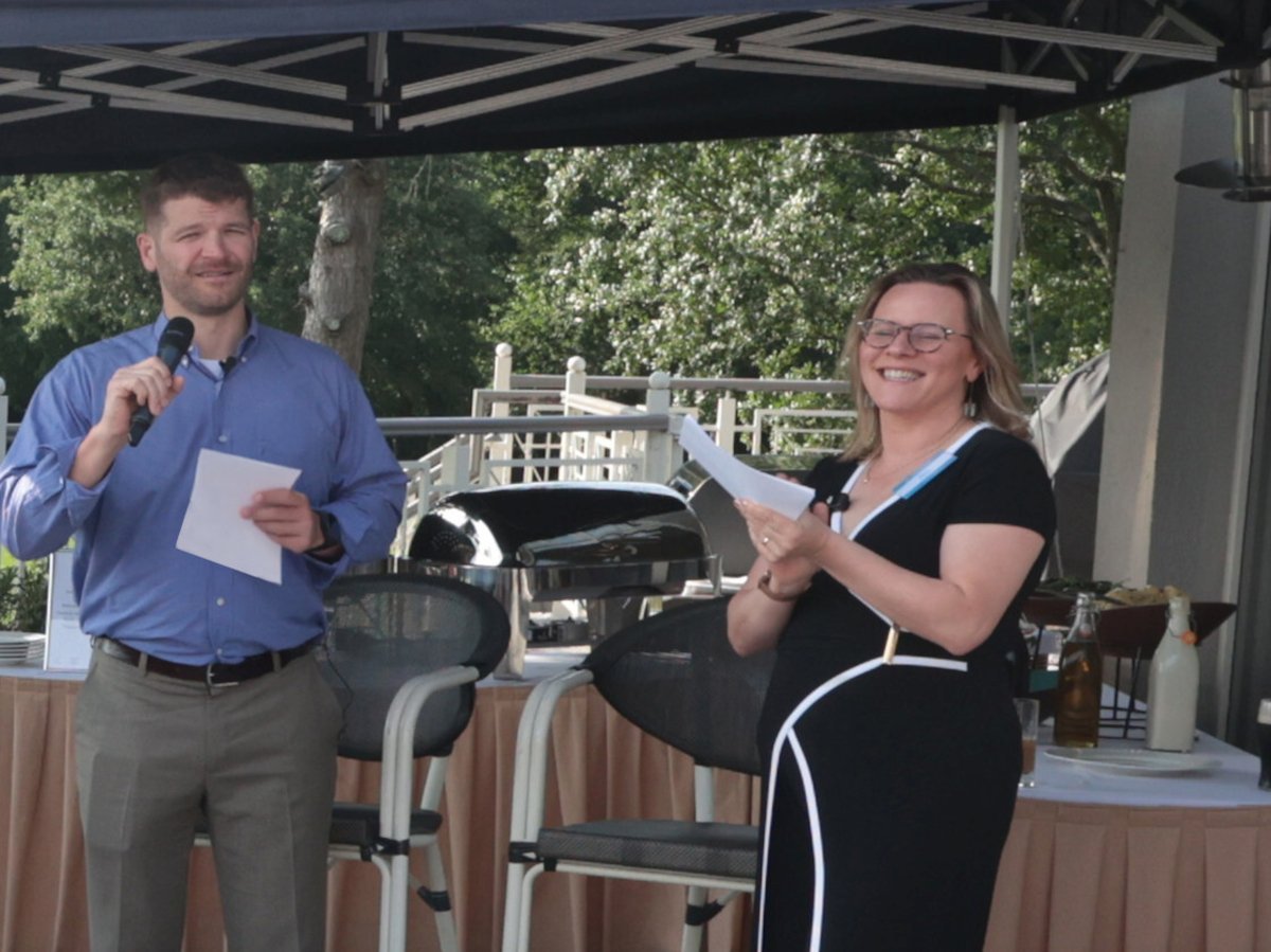 a man and a woman with handheld microphones at a Barbeque