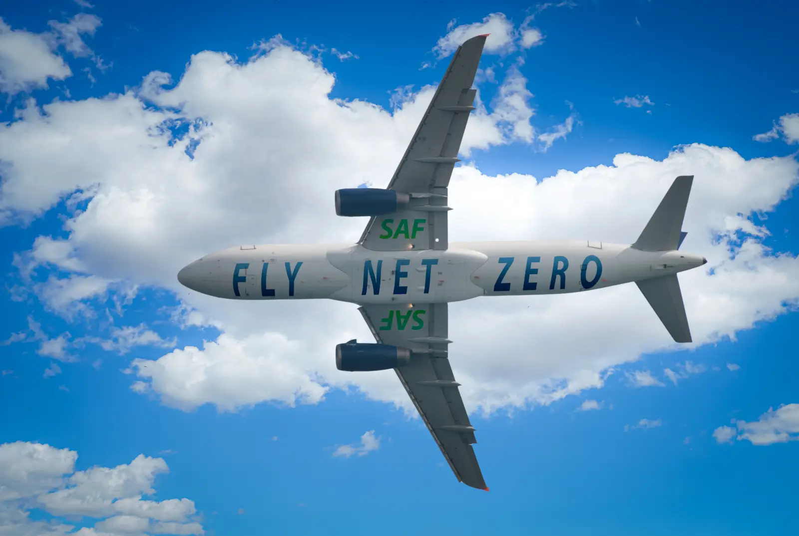 Airplane in flight with “Fly Net Zero” and “SAF” painted on its body and engines, promoting sustainable aviation fuel.
