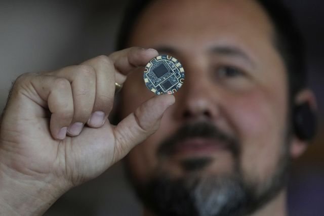FILE - Jason Rugolo, founder and CEO of iyO, shows the motherboard of the iyO One audio computer while being interviewed at the company