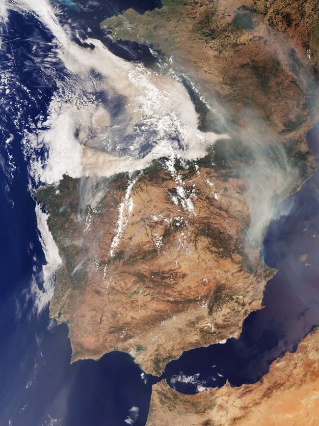 Iberian Peninsula wildfires: Satellite view looking at Spain, Portugal and France with thick smoke swirling near the top.