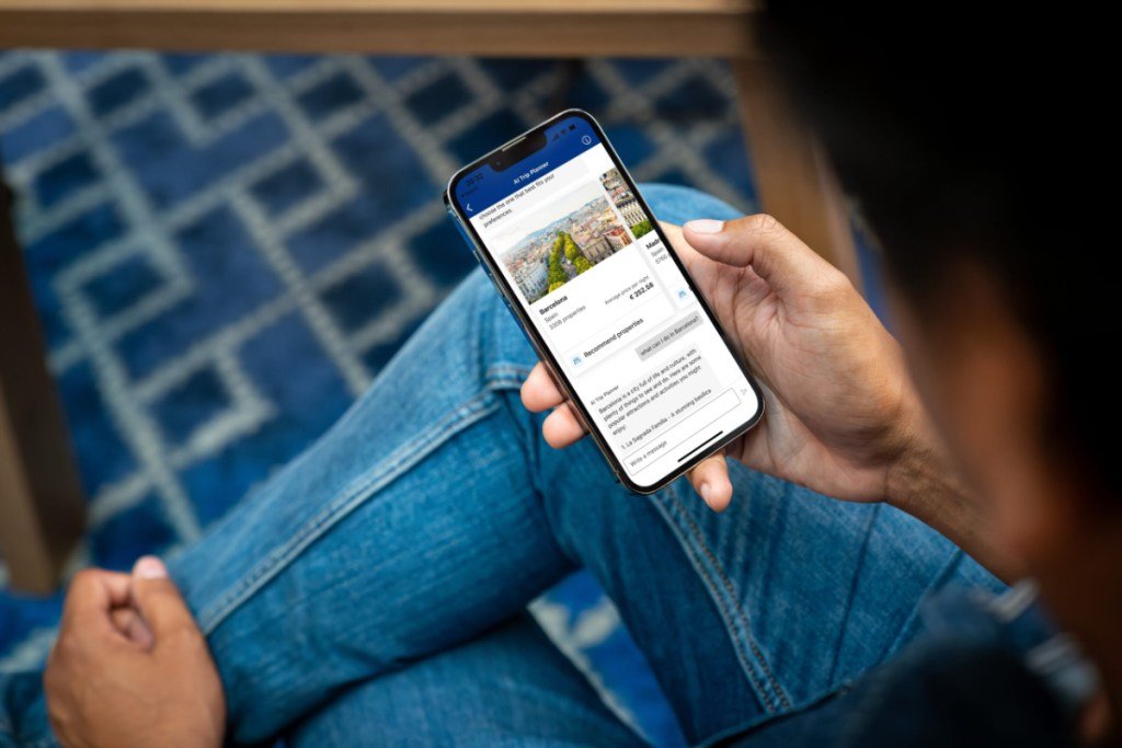a person holding a phone with the Booking.com app open