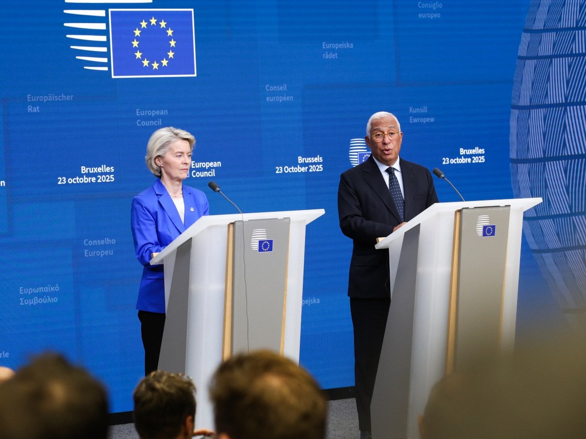 A woman in a blue blazer and a man in a black suit standing at two podiums speaking.