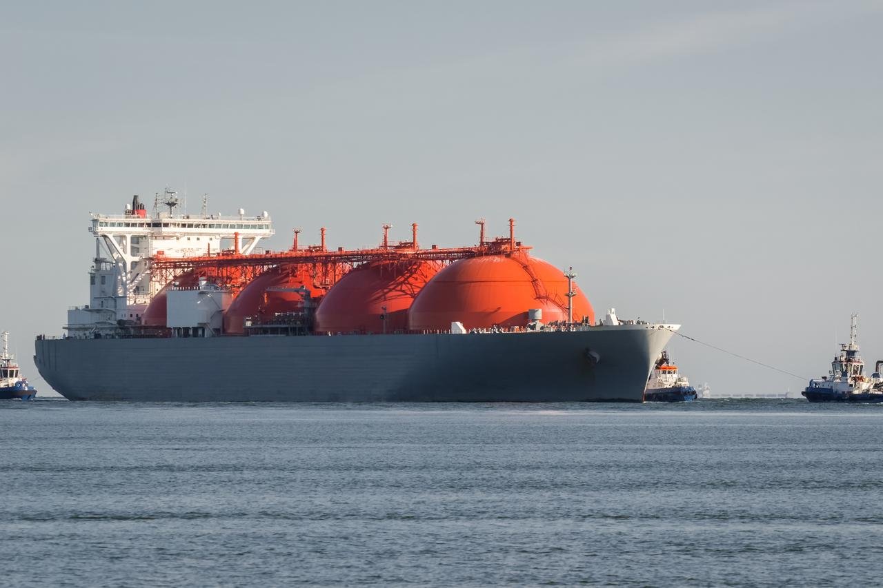 View of a liquefied natural gas (LNG) carrier escorted by tugboats at sea. (Adobe Stock Photo)