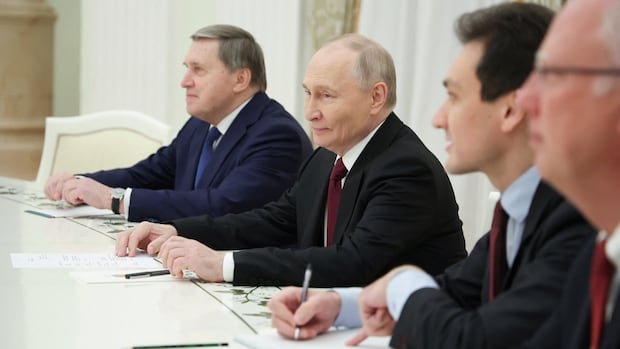 Men in suits sit at a table.