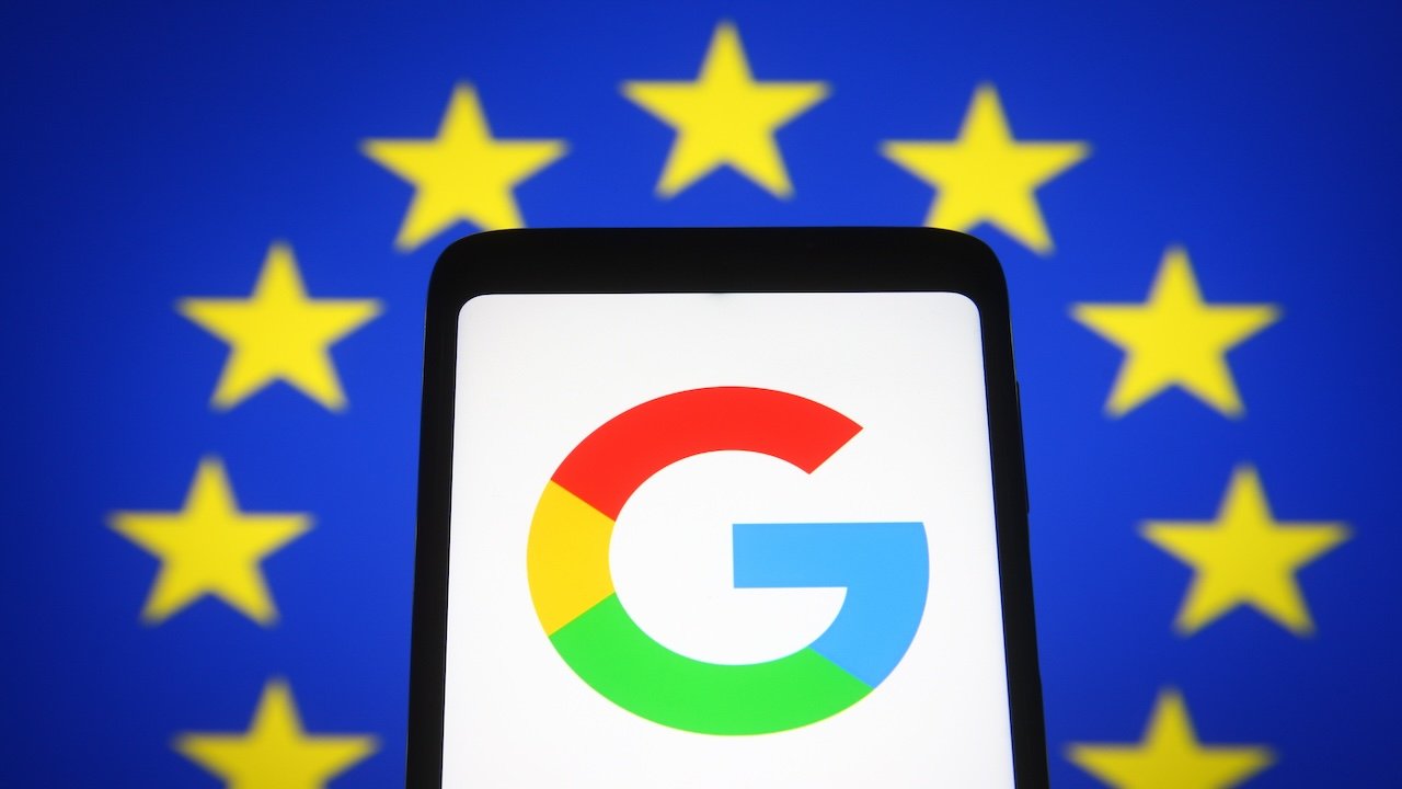 In this photo illustration Google logo is seen on a mobile phone screen in front of the European Union flag