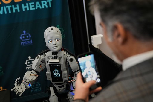 A man records a humanoid robot inside the exhibition room at the Humanoids Summit, Thursday, Dec. 11, 2025, in Mountain View, Calif. (AP Photo/Godofredo A. V&aacute;squez)