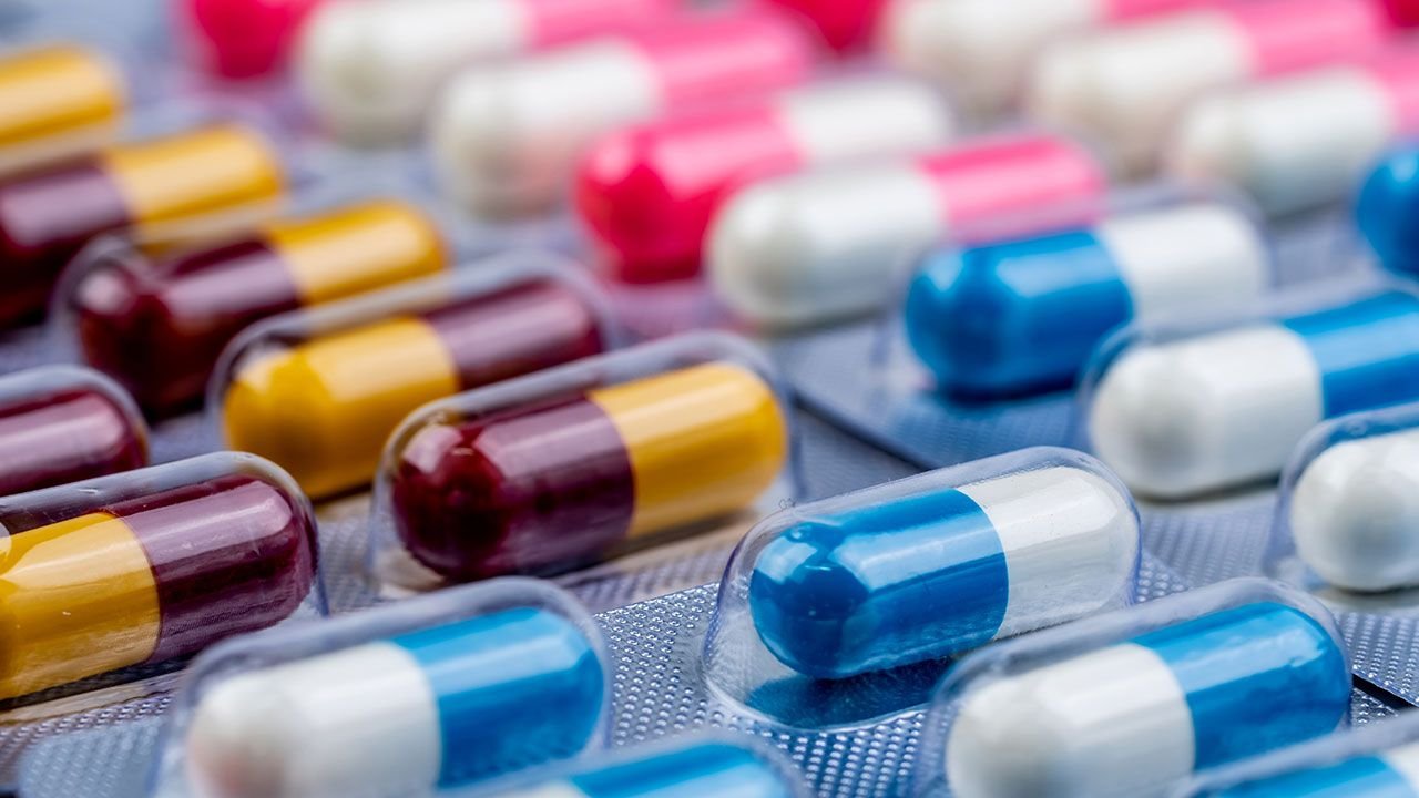 Young woman after chemotherapy taking pills from nurse in hospital room. Brain cancer concept