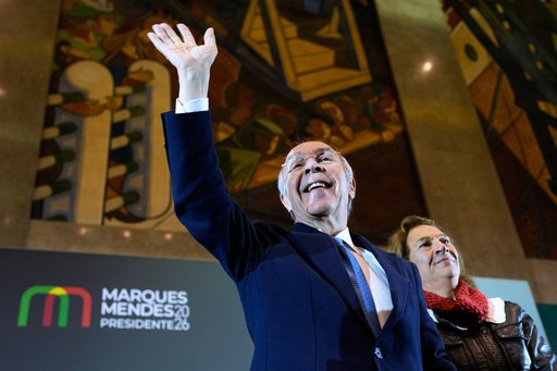 Presidential candidate Luis Marques Mendes, from the center-right Social Democratic Party, with his wife Rosa Sofia Salazar, gestures to supporters while campaigning for Sunday