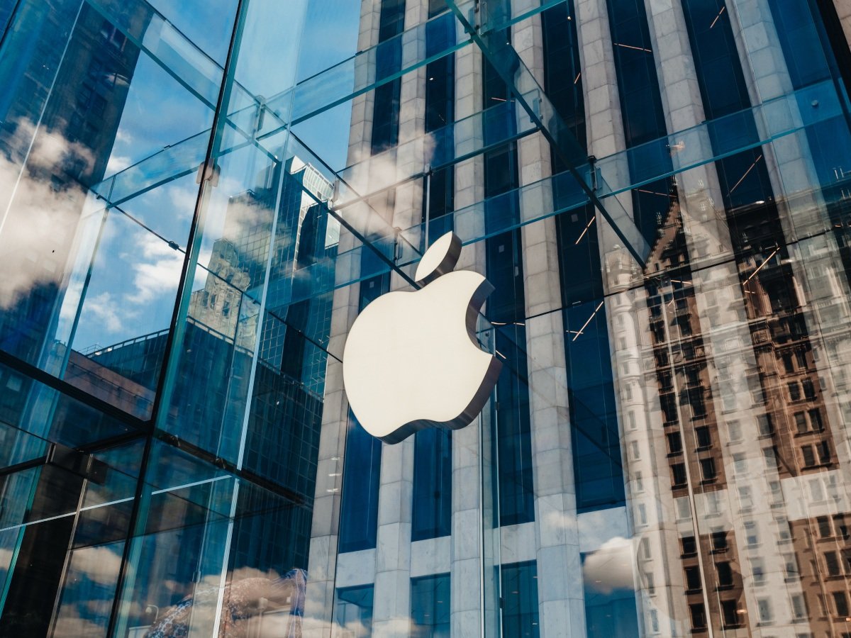 The Apple logo overlaid on a glass window pane at one of its locations in New York city.