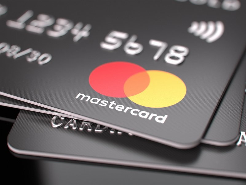 The Mastercard logo on the front of a credit card, with other cards under it.